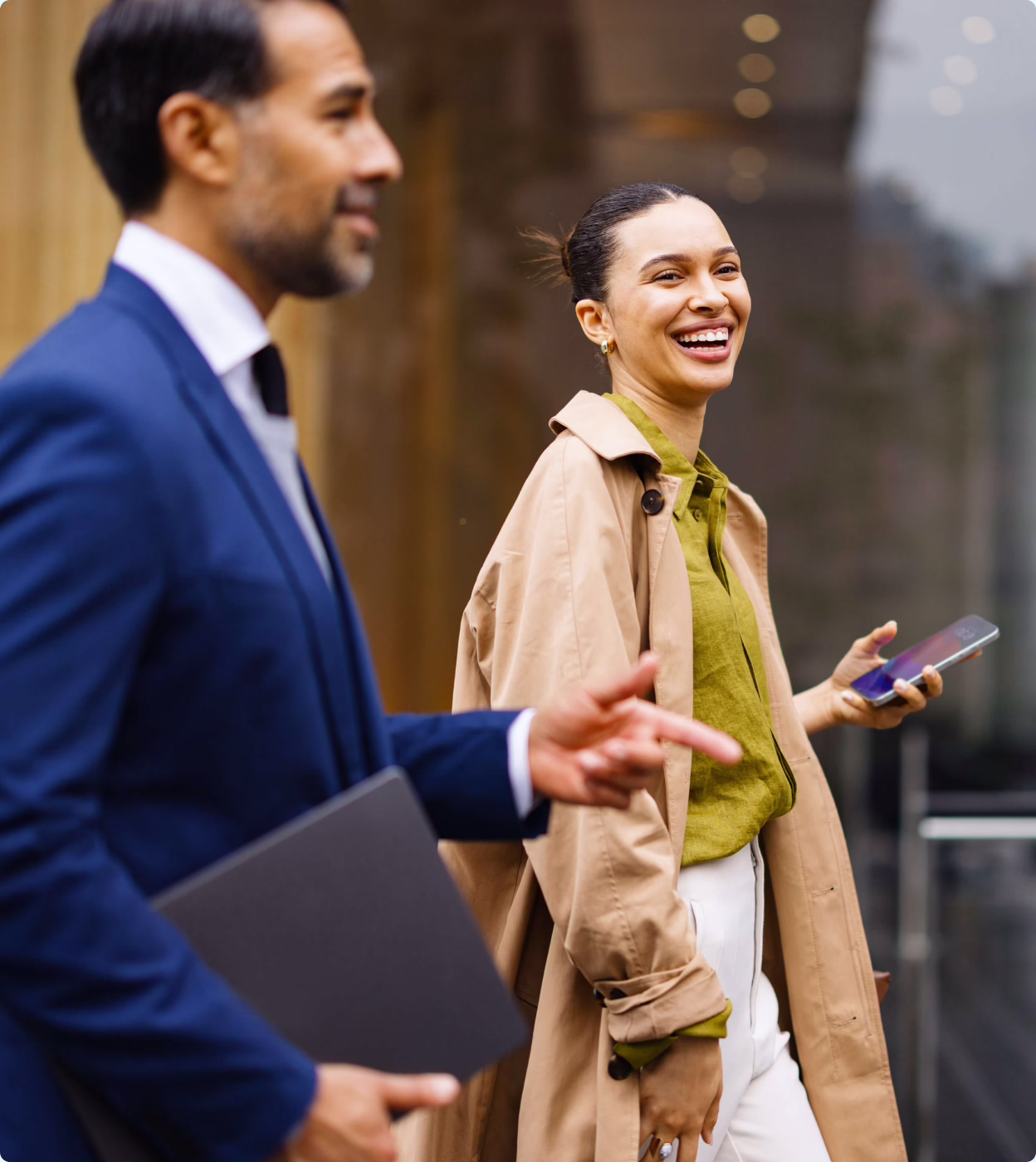 Two colleagues talking while walking outside an office building